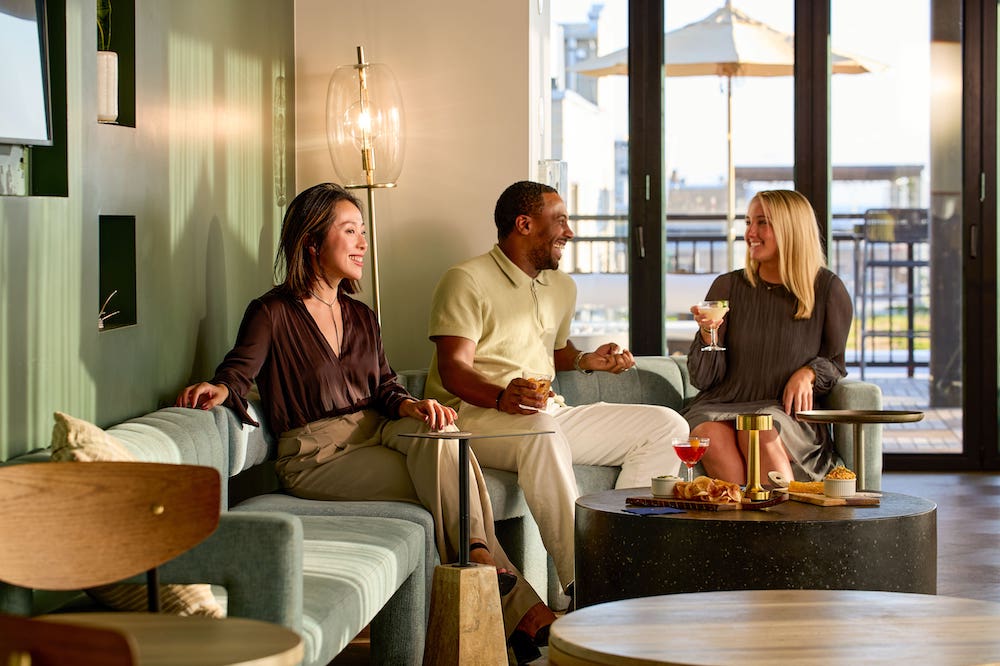 Three people laughing and enjoying a drink