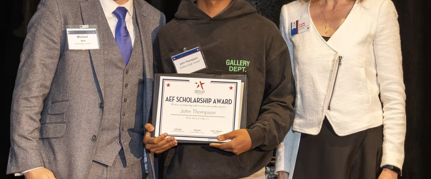 John Thompson holds his AEF scholarship in between Michael Akin and Claire Carlin