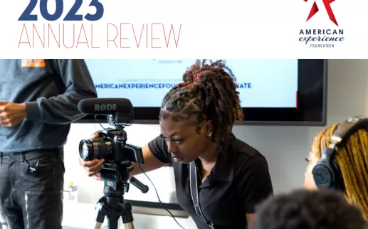 Annual Review 2023 - a young Black woman sits behind a camera filming