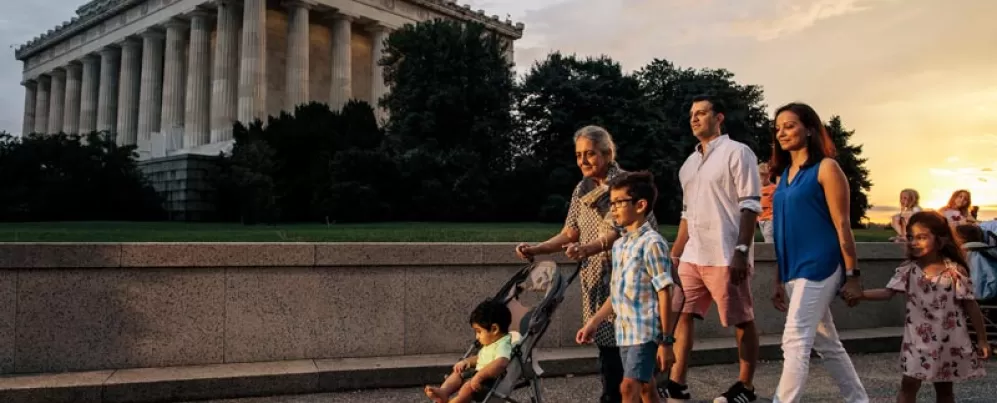 Family walking on the National Mall in front of the Lincoln Memorial during a summer evening in Washington, DC